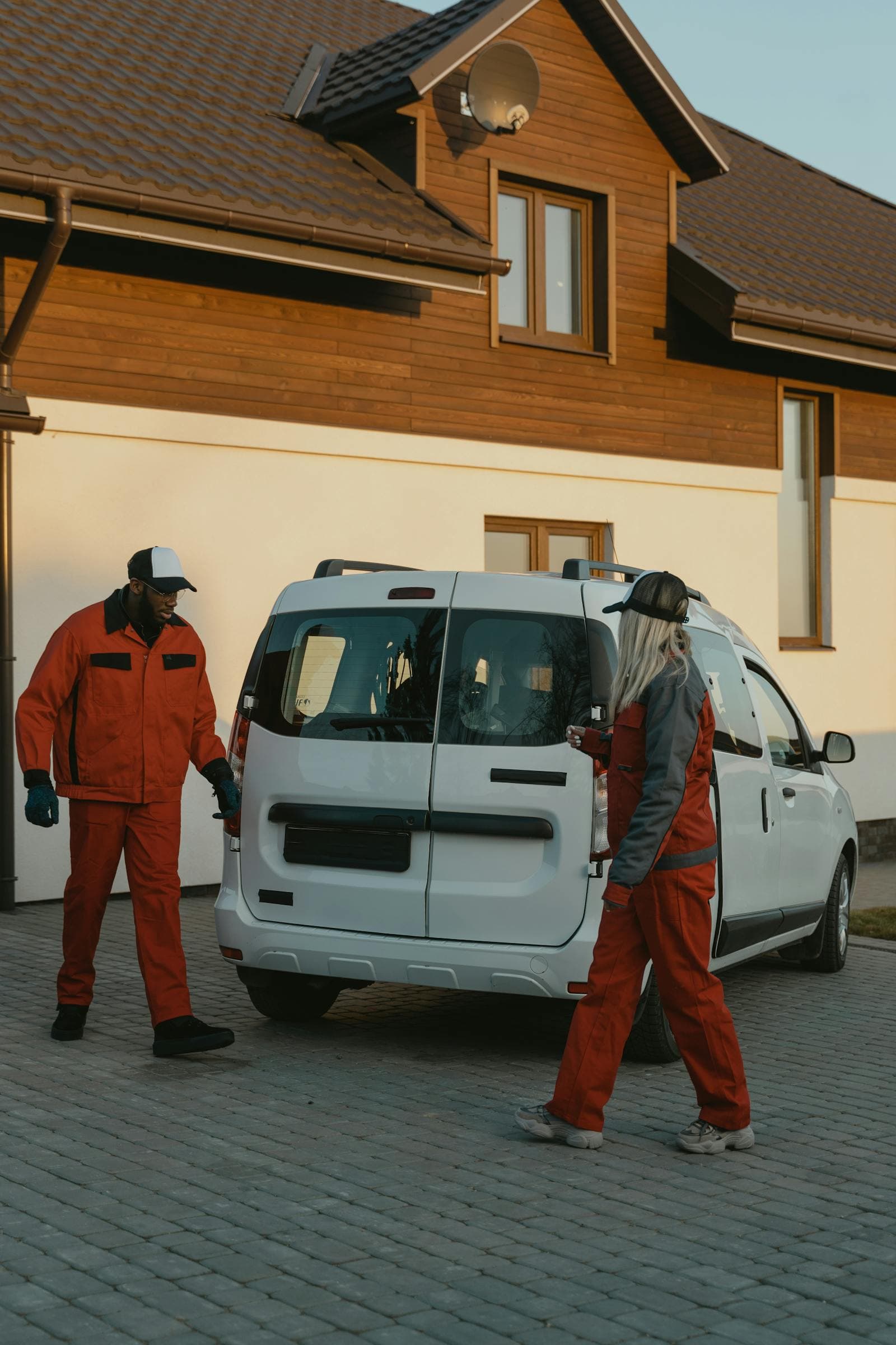 Professional service team standing beside a service van outside a client property